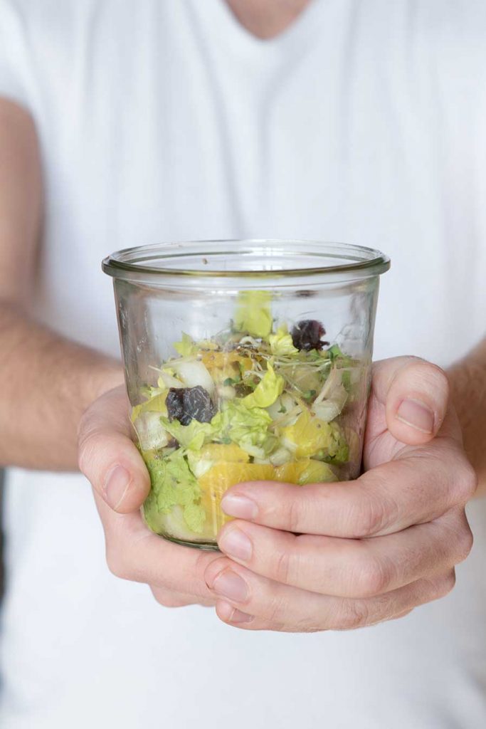 Salat im Glas in der Hand
