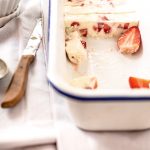 Angeschnittenes Eis mit Erdbeeren und einem Messer daneben